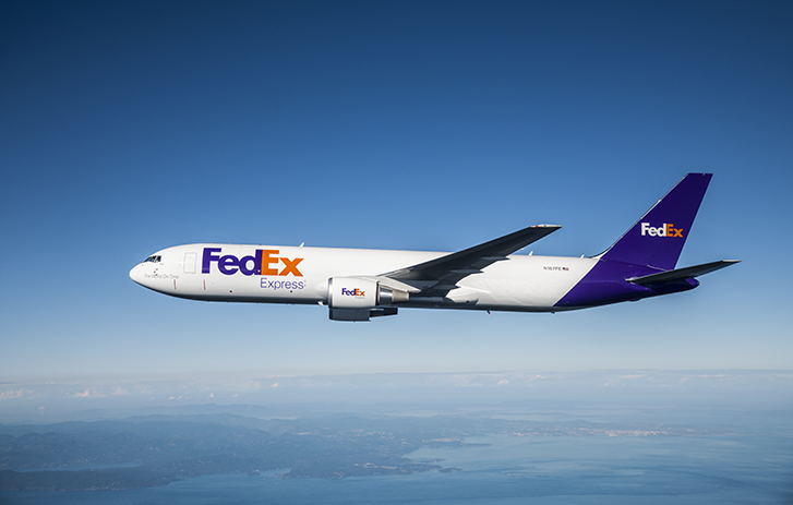 FedEx plane flying above the horizon