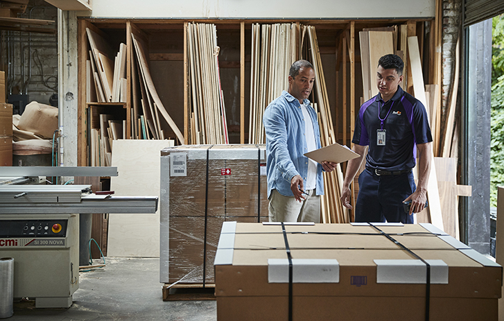 Customer holding a clipboard talking to a FedEx courier