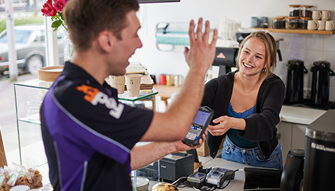 FedEx courier handing a package to a smiling customer