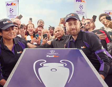 FedEx Kuriere, die die UEFA Trophäe in einer speziellen Verpackung tragen