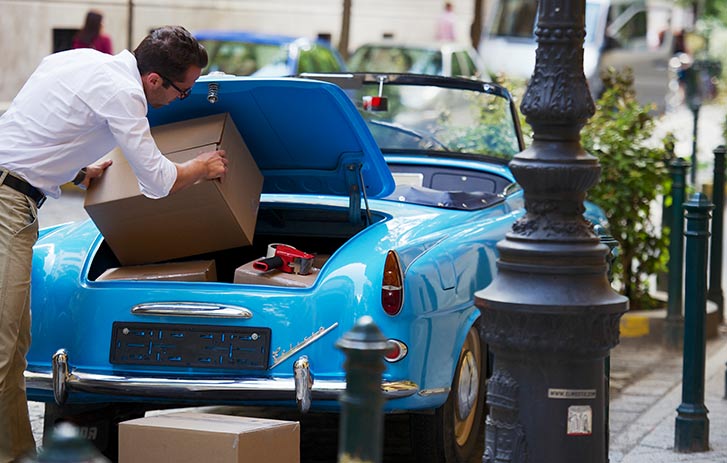 Man putting package into car