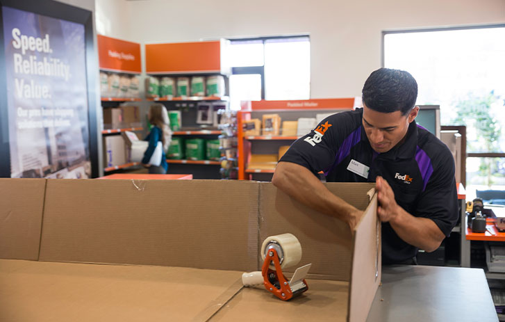 Image of a FedEx employee creating a custom box solution.