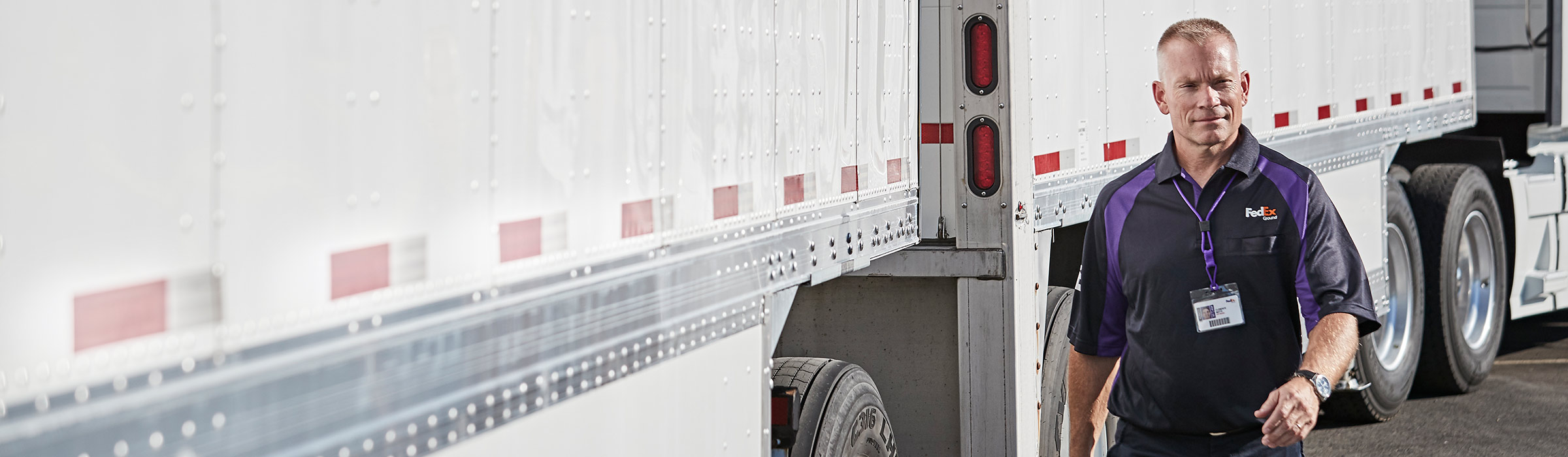 Courier walks near FedEx trucks to deliver packages