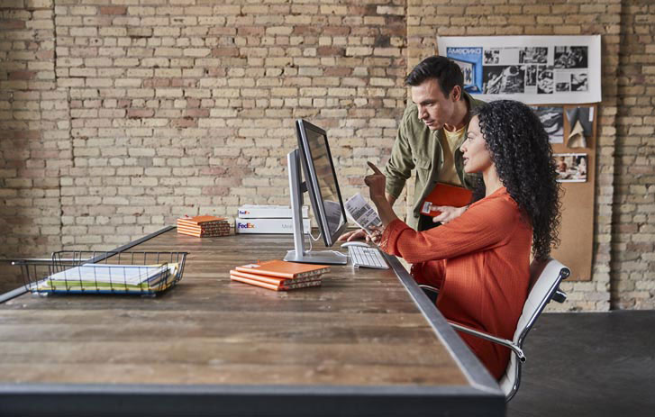 two people browsing desktop computer