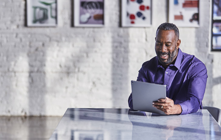 man using tablet at a desk