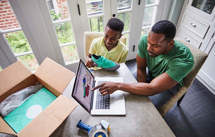 A father and son working on a computer.