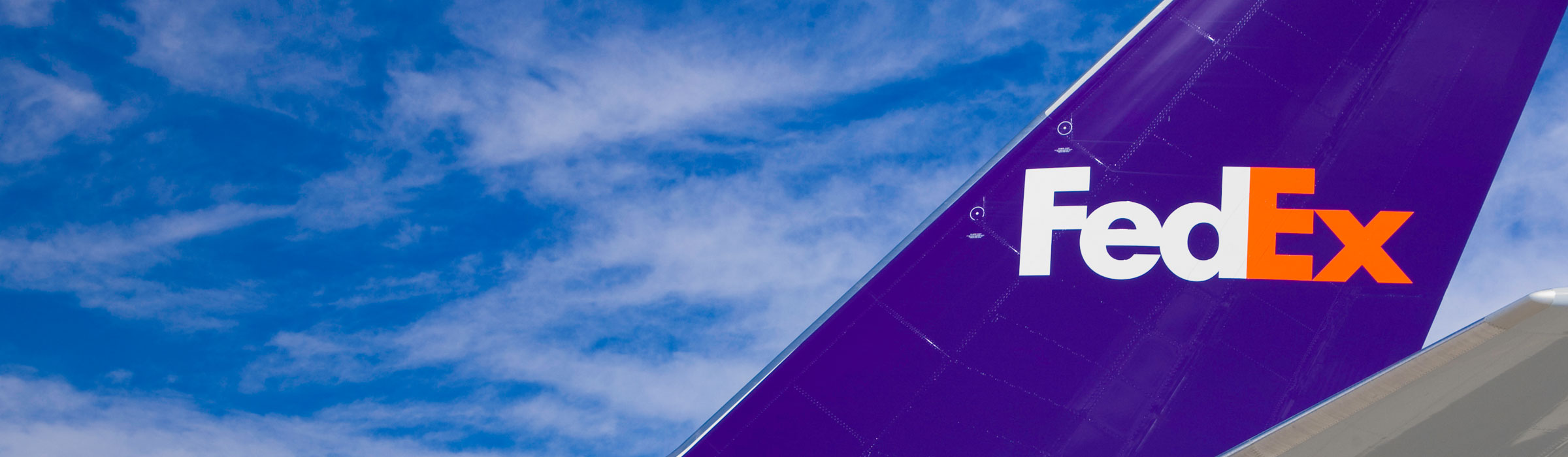 Wing of a FedEx place over a blue sky