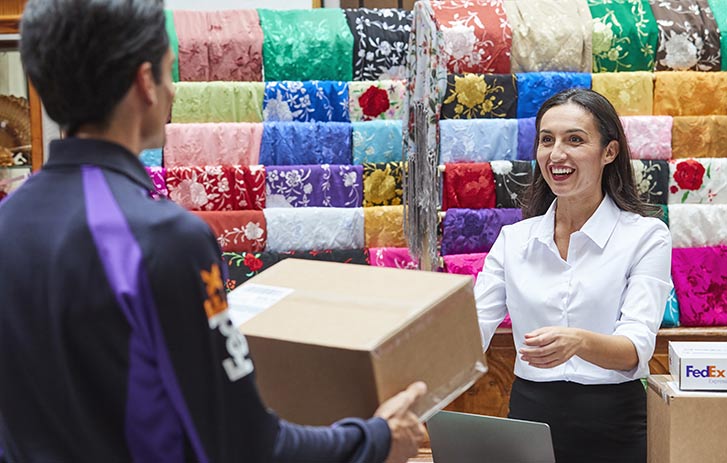 A FedEx courier picks up a package from a clothing store.