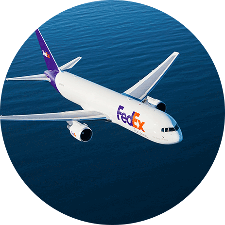 FedEx airplane in mid-flight over water