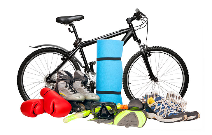 Image of a bicycle surrounded by, boxing gloves, skates, yoga mat, goggles, and sneakers.