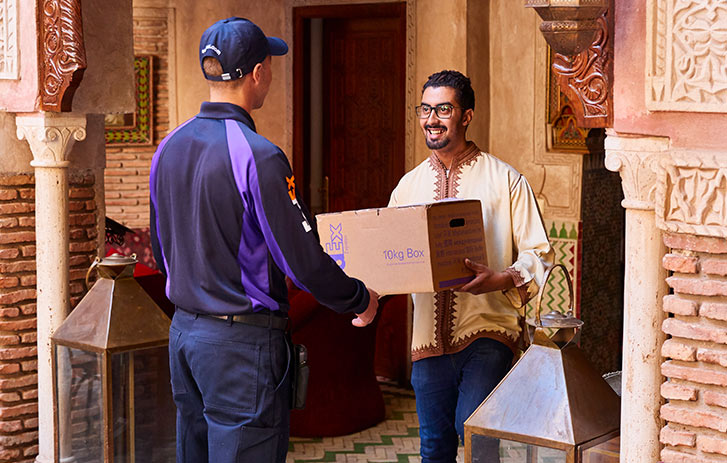 Courier delivering international shipment to smiling man